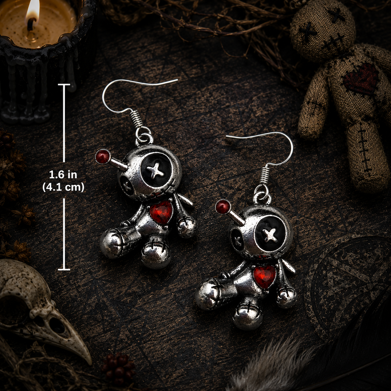Silver voodoo doll earrings with button eyes and a red heart accent—creepy yet cute.
